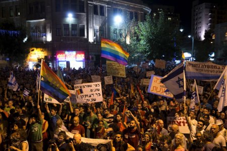 People take part in a rally to condemn an attack on the annual Gay Pride parade in Jerusalem