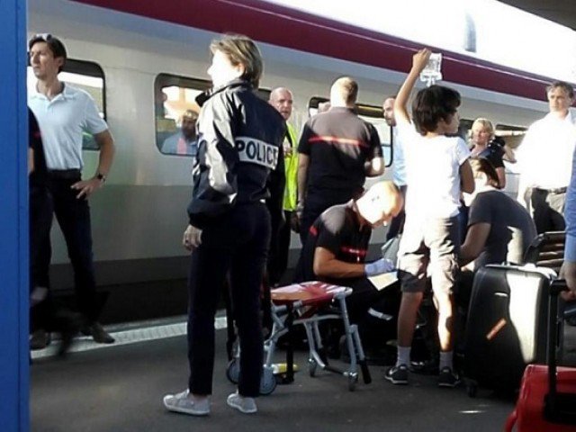 A police officer stands by as a passenger receives medical attention in Arras northern France after being injured