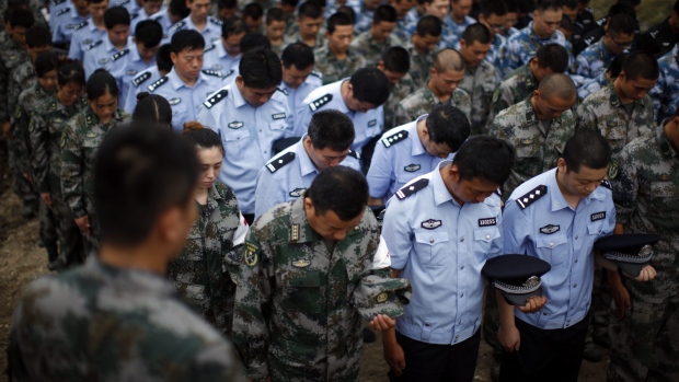 Soldiers policemen and paramilitary policemen attend a mourning service for the victims in the chemical explosions at the blast site in Tianjin China