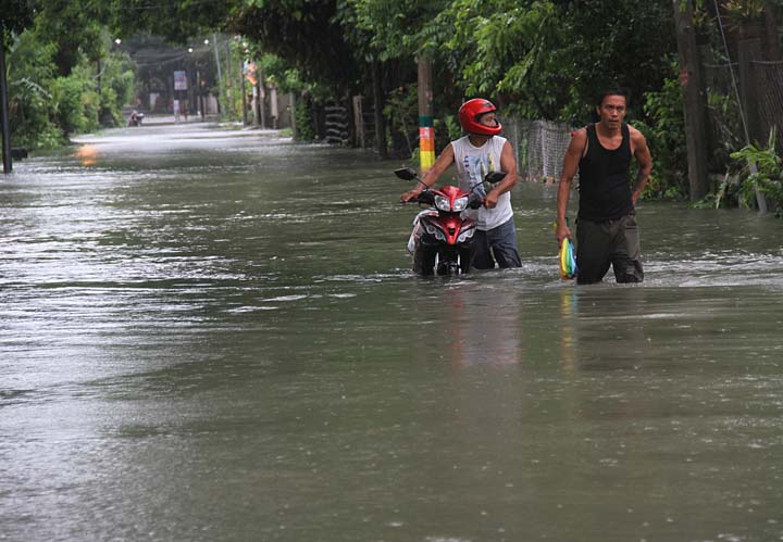 FLOOD AGAIN Residents walks on a knee deep flooded area of Barangay Poblacion Bacnotan La Union brought by monsoon rain of typhoon “Ineng” afternoon