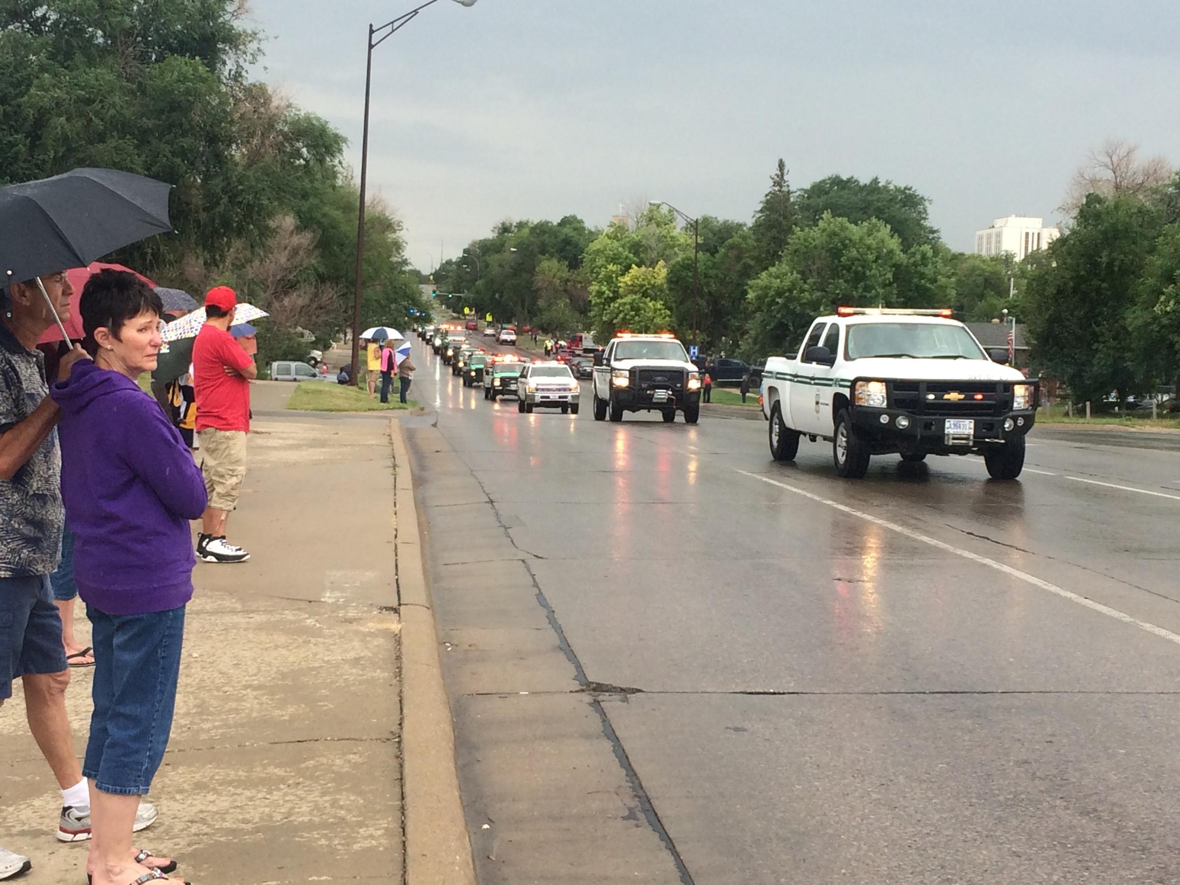 Rapid City residents line 5th street as the procession for fallen firefighter Dave Ruhl makes it's way to the Sunday afternoon memorial service