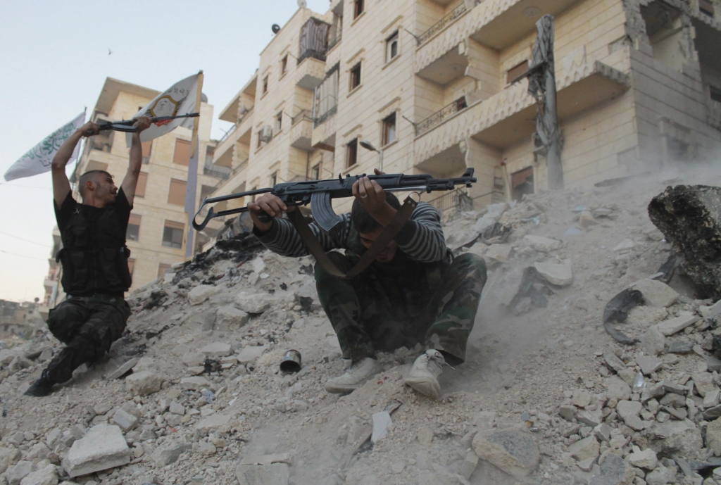 Free Syrian Army fighters fire their weapons during what the FSA said were clashes with forces loyal to Syria's President Bashar al Assad in Aleppo's Karm al Jabal district