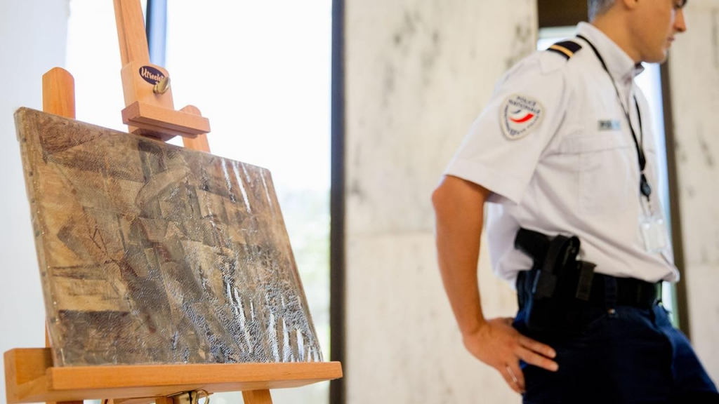 An officer stands guard next to Pablo Picassos painting entitled La Coiffeuse Thursday Aug. 13 2015 at the French Embassy in Washington