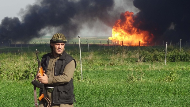 A member of the Kurdish Peshmerga forces walks at the Khubbaz oil field some 25 kilometres west of the northern city of Kirkuk in a file