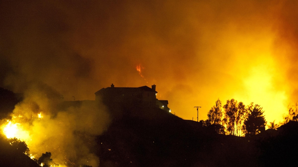 A firefighter monitors flames from the Rocky Fire as it approaches a home late last month. The wildfire has consumed thousands of acres in just over a week