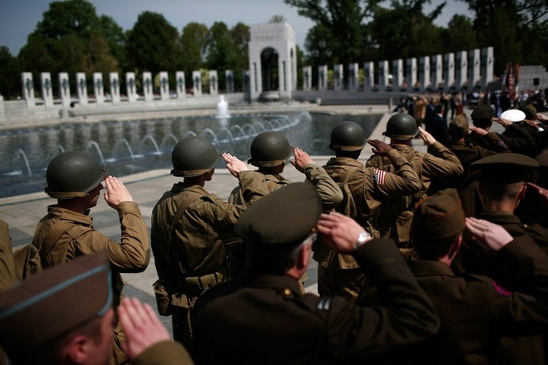 World War II reenactors salute while the American National Anthem plays during a ceremony commemorating the 70th Anniversary of VE Day at the National World War II Memorial