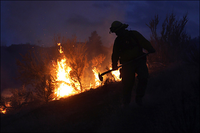 A makeshift fire truck puts water on a wildfire which is part of the Okanogan Complex as it burns through brush