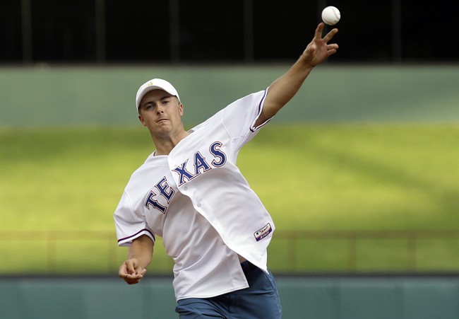 PGA golfer Jordan Spieth throws the first pitch before a baseball game between the Seattle Mariners and Texas Rangers in Arlington Texas Tuesday Aug. 18 2015