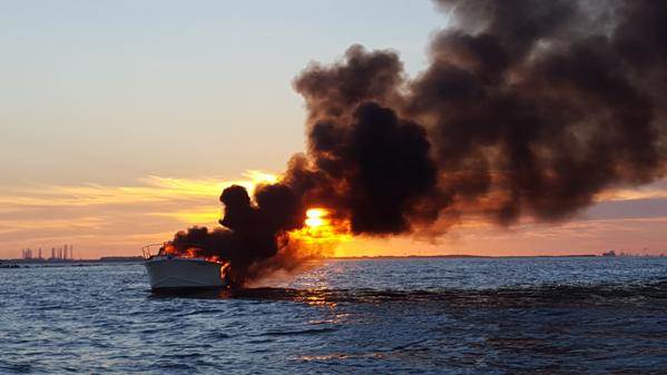 A yacht is seen on fire after four people were rescued by a boater in the waters near Galveston Texas on Saturday. U.S. Coast Guard