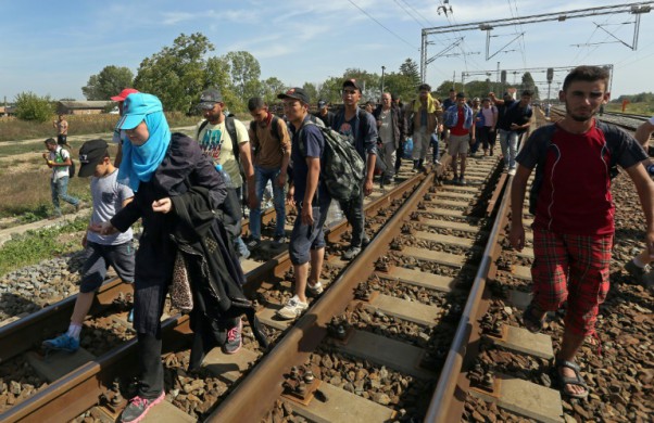 AFP  Migrants walk on railway tracks towards the train station of Tovarnik close to the Croatian Serbian border