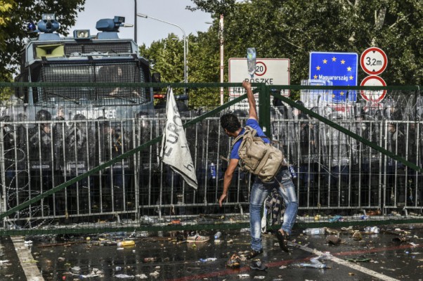 AFP  File  Armend NimaniA refugee throws a bottle of water towards Hungarian riot police after they used water cannon to push back refugees at the Hungarian border with Serbia near the town of Horgos