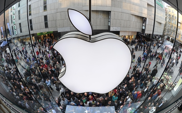 A giant Apple logo can be seen as customers wait for the new Apple iPad 2 in front of the Apple-store in the southern German city of Munich