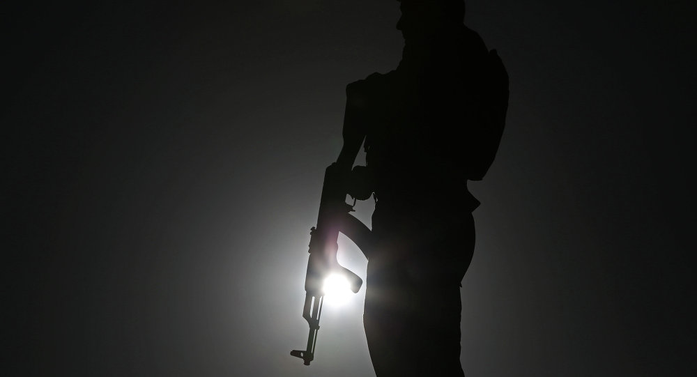 An Afghan police officer stands guard during a campaign rally in the Paghman district of Kabul Afghanistan Monday