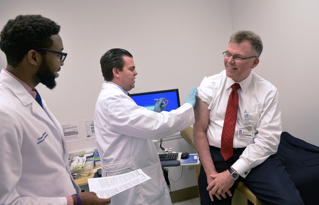 20150909lrvaccinehealth05-4 Matthew W. Eberts center director of pharmacy for West Penn Hospital demonstrates how to administer a vaccine to Ron Andro right the CEO of West Penn Allegheny Health System in the special clinic at West Penn Hospital. At