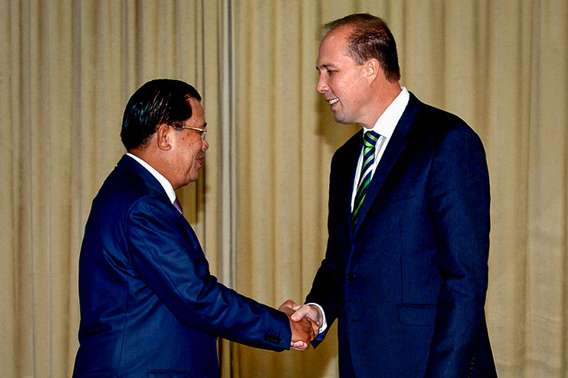 Prime Minister Hun Sen left shakes hands with Australian Immigration Minister Peter Dutton at Mr Hun Sen's office building in Phnom Penh on Wednesday