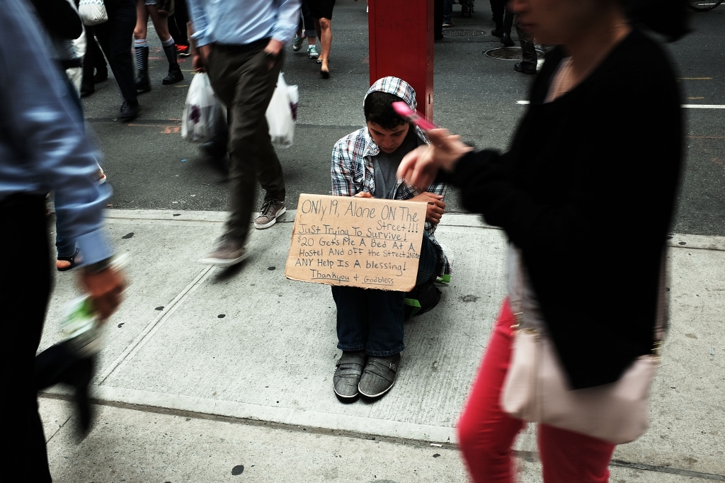 FILE- A homeless teen panhandles on a street near Eighth Avenue in Manhattan