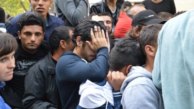 Hundreds of migrants queue up outside the German State Office for Health and Social Affairs on Monday