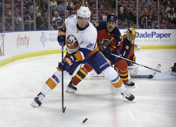 New York Islanders center Brock Nelson and Florida Panthers defenseman Willie Mitchell go for the puck in the first period of an NHL hockey game in Sunrise Fla. The New York Islanders re-s