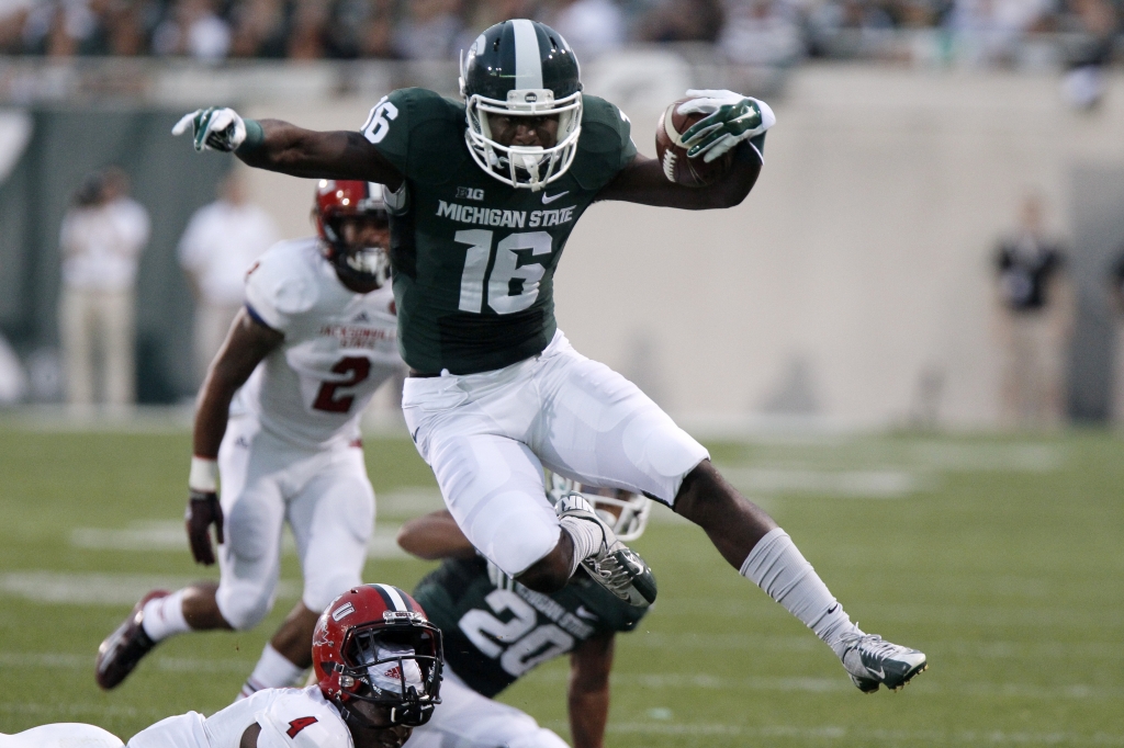 EAST LANSING MI- AUGUST 29 Wide receiver Aaron Burbridge #16 of the Michigan State Spartans hurdles safety Folo Johnson #4 of the Jacksonville State Gamecocks on a 15-yard run during the first quarter at Spartan Stadium