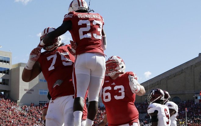 Wisconsin's Dare Ogunbowale celebrates his touchdown run offensive linemen Micah Kapoi and Michael Deiter