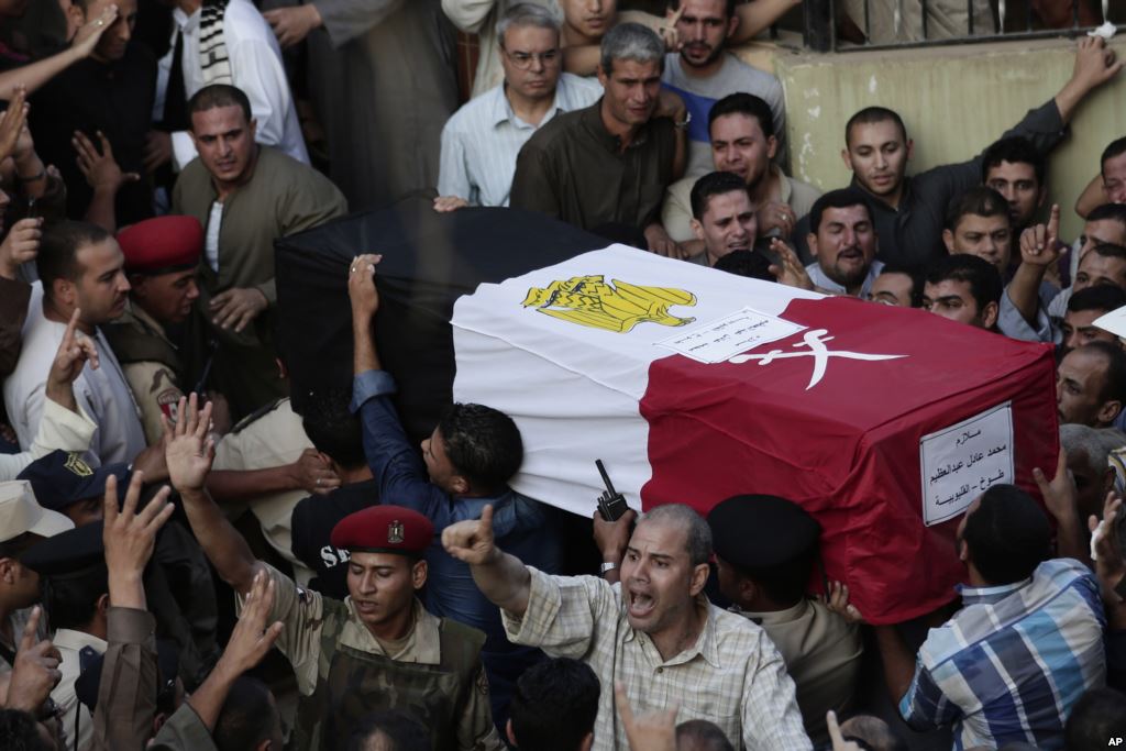 FILE- Egyptians carry the coffin of 1st Lt. Mohammed Adel Abdel Azeem killed in an attack by Islamic militants in the Sinai during the funeral procession at his home village of Tant Al Jazeera in Qalubiyah north of Cairo