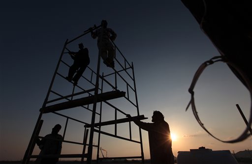 Asian workers set up a campsite at sunset in the desert oil fields of Sakhir Bahrain. Across a Mideast fueled by oil production low global prices have some countries running on empty and scrambling to cover shortfalls even as more regional crude is