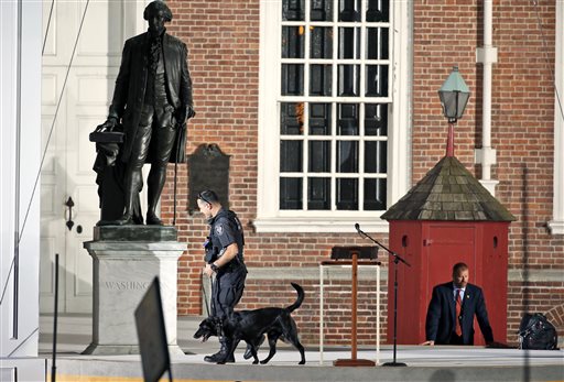 Law enforcement sweep the area in front of Independence Hall with the statue of President George Washington at left before the arrival of Pope Francis where he is expected to speak from the lectern used by President Abraham Lincoln during the Gettysburg