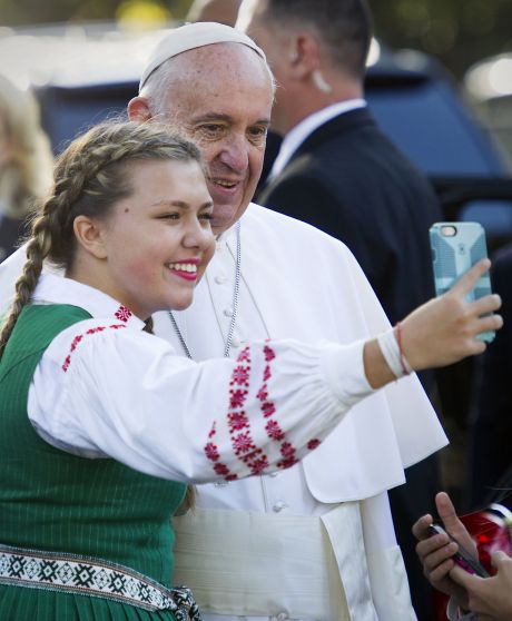 Pope Francis poses for a selfie with a school girl who's parent work at the Lithuanian Embassy as he prepares to depart the Apostolic Nunciature the Vatican's diplomatic mission in Washington Wednesday Sept. 23 2015. Pope Francis will visit the White