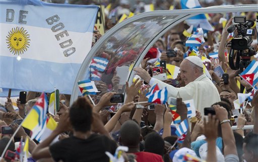 Pope Francis arrives for Mass at Revolution Plaza in Havana Cuba Sunday Sept. 20 2015 where people wave Cuban Vatican and Argentine flags. Pope Francis opens his first full day in Cuba on Sunday with what normally would be the culminating highlight