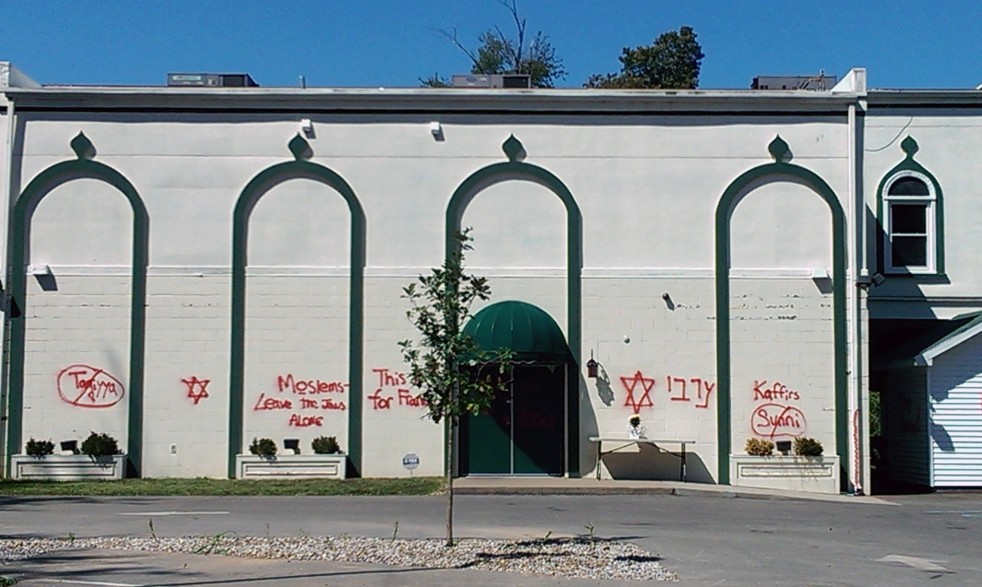 Red graffiti on the exterior of the Louisville Islamic Center building in Louisville Kentucky