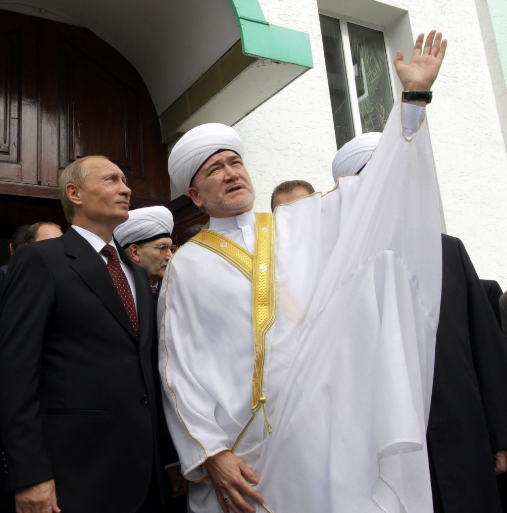 Russia's Prime Minister Vladimir Putin listens to the leader of all Muslims in Russia Ravil Gaynutdin during their meeting in a mosque in Moscow