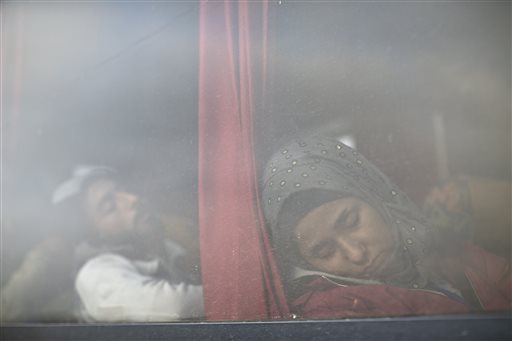 Migrants sleep inside a bus as they wait to be admitted into a registration center for migrants and refugees in Opatovac Croatia Thursday Sept. 24 2015. Serbia has banned imports of Croatian goods and Croatia has retaliated by barring vehicles with Se