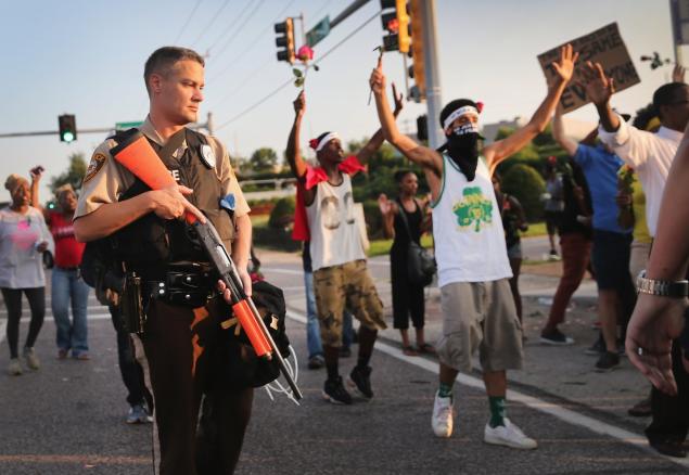 Armed officers are seen attending a demonstration against Brown's 2014 shooting death in Ferguson Mo. Johnson Shanks appears to have criticized the violence that followed Brown's death