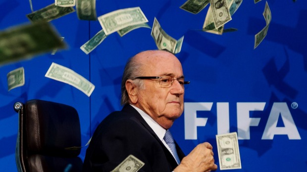 Comedian Simon Brodkin throws dollar bills at FIFA President Joseph Blatter during a press conference in Zurich in July. The corruption probe into football's governing body continues