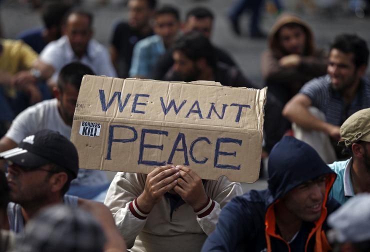 A Syrian man holds a banner asking for peace