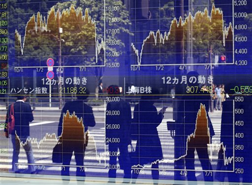 People are reflected on the electronic board of a securities firm in Tokyo Monday Sept. 28 2015. Asian stocks were mostly lower Monday following Wall Street's loss last week as investors looked ahead to Chinese and U.S. economic data. (AP