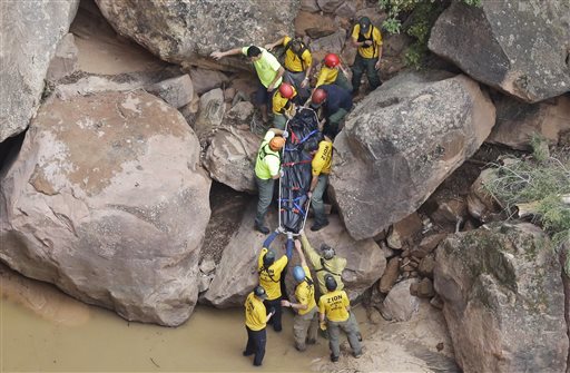 Search and rescue team members carry a body after it was found along Pine Creek Wednesday Sept. 16 2015 in Zion National Park near Springdale Utah. Authorities are searching for other hikers killed in flash flooding that swept through a narrow canyo