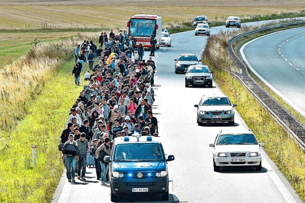 A group of migrants walking along a road