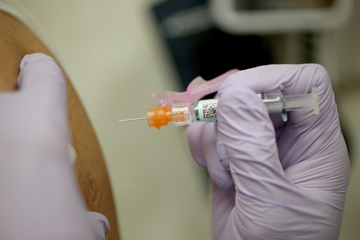 A Walgreens employee administers a flu shot at a free flu shot clinic in Oakland California