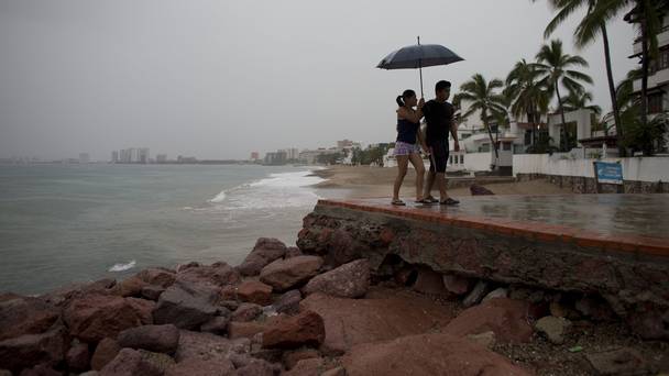 A couple walks along the waterfront under a steady rain as rainfall increases with the approach of Hurricane Patricia in Puerto Vallarta