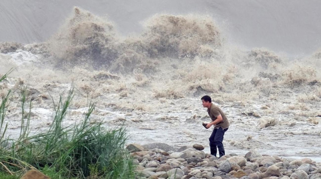 A resident collects stones from the Xindian river after typhoon Dujuan passed New Taipei City