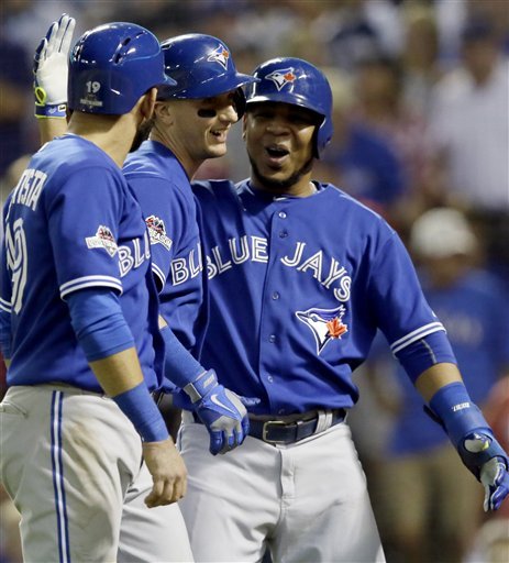 After hitting a three-run home run against the Texas Rangers Toronto Blue Jays shortstop Troy Tulowitzki center celebrates with right fielder Jose Bautista, and designated hitter Edwin Encarnacion, right during the sixth inning in Game 3 of