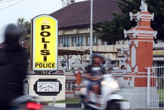 Motorcyclists pass by Denpasar's police station where Rajendra Sadashiv Nikalje is detained in Bali Indonesia Monday Oct. 26 2015