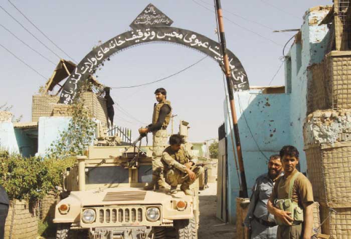 Afghan security forces stand guard at the main gate of the prison after retaking Kunduz from the Taliban in Kunduz on Thursday. — AFP