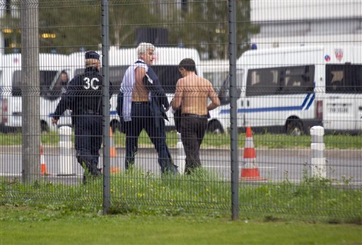 Air France director of Human Ressources Xavier Broseta right and Air France assistant director long-haul flight Pierre Plissonnier center are protected by a police officer as they flee Air France headquarters at Roissy Airport north of Paris after