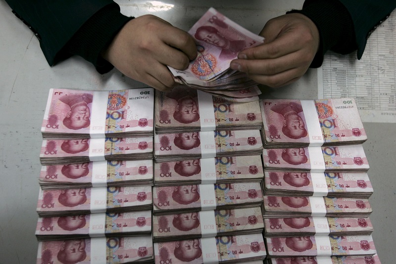 An employee counts yuan banknotes at a branch of Bank of China in Taiyuan. – Reuters pic