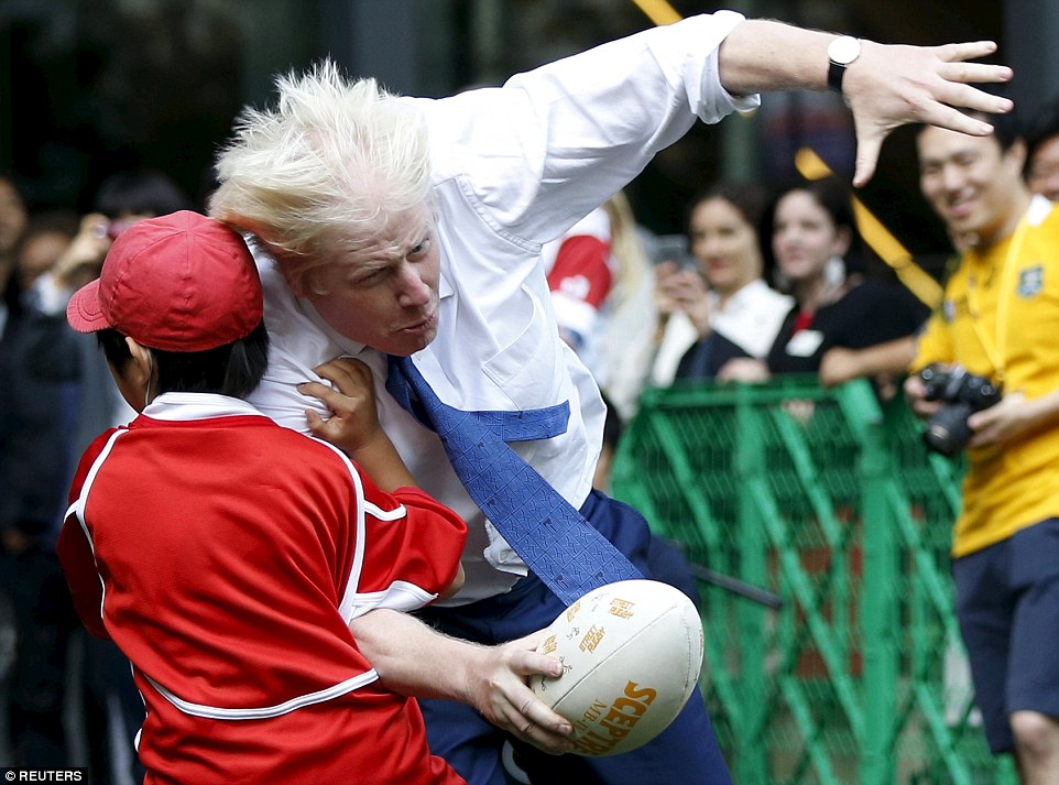 Boris Johnson sent a child sprawling on the floor after he bundled into him full force during a'friendly game of street rugby in Japan