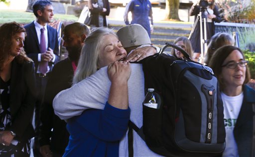 Umpqua Community College interim President Rita Cavin hugs an unidentified person on campus as the school reopens Monday Oct. 12 2015 after being closed since the multiple fatality shooting on Oct. 1 in Roseburg Ore. (Beth Nakamura  The Oregonian via