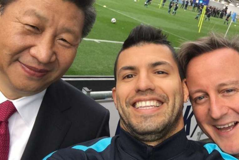 Manchester City's Argentinian striker Sergio Aguero poses for a'selfie with Xi and British Prime Minister David Cameron during their visit to the City Football Academy