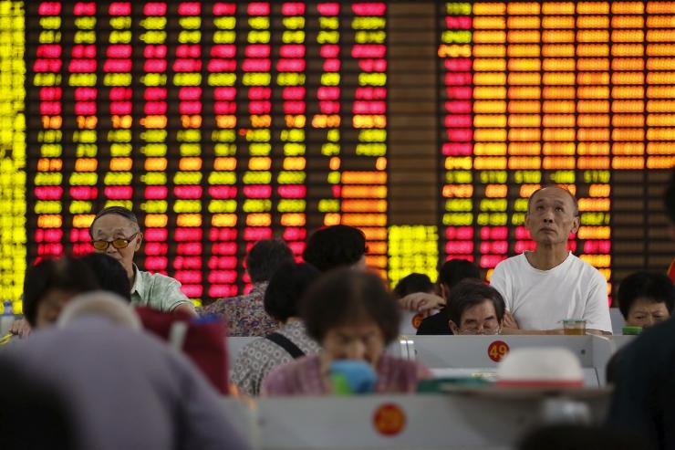 Investors look at computer screens showing stock information at a brokerage in Shanghai China